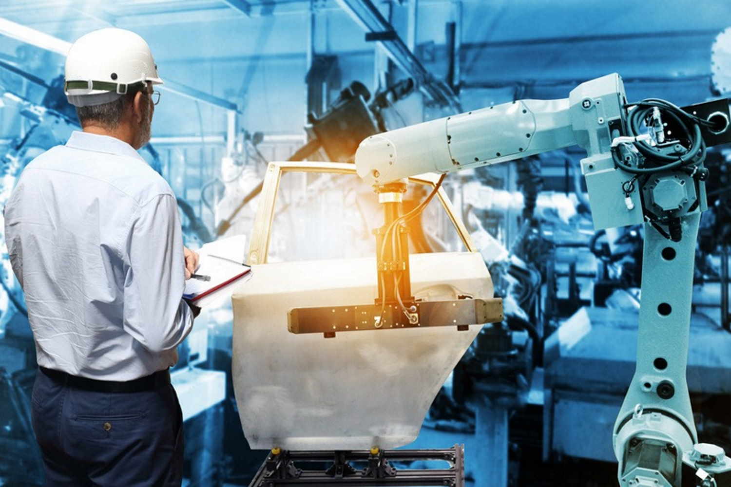 Ein Arbeiter überwacht einen Roboterarm der Automobilindustrie, der an einer Autotür arbeitet