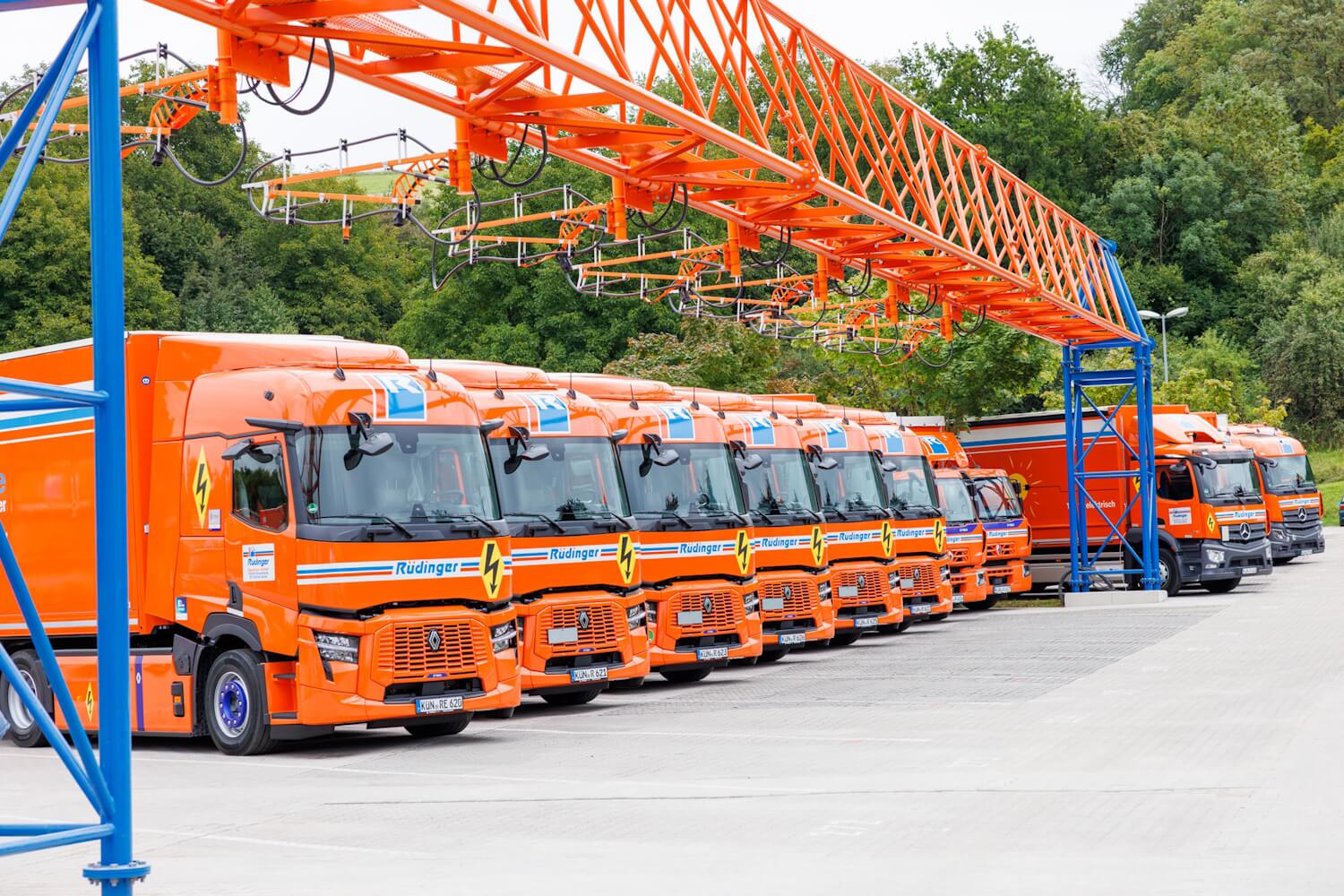 E-Lkw-Ladepark mit Overhead-Ladeinfrastruktur, an der sieben Ladepunkte montiert sind.