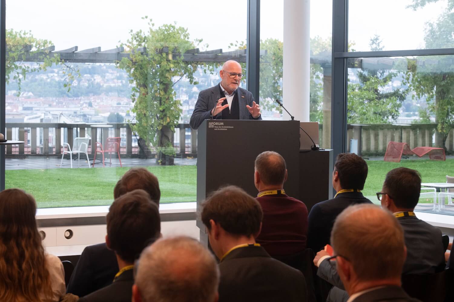 Verkehrsminister Winfried Hermann steht auf dem Podium und hält eine Eröffnungsrede bei einer Veranstaltung.