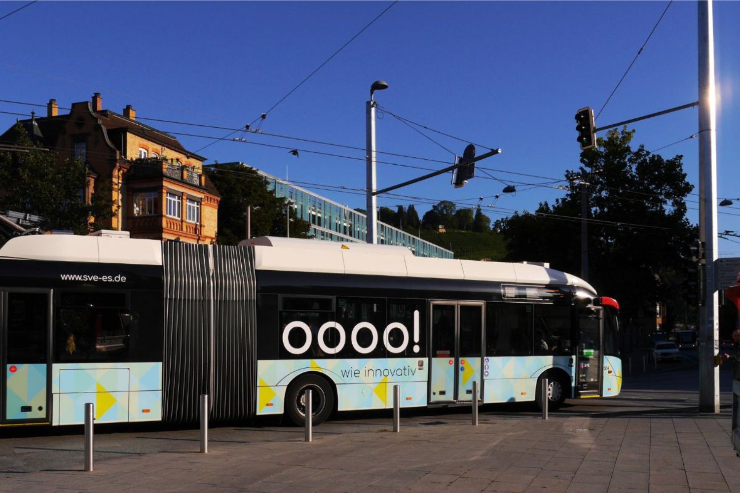 Ein Gelenkbus fährt in Esslingen unter einer Oberleitung, über die er während der Fahrt seinen Batteriespeicher lädt