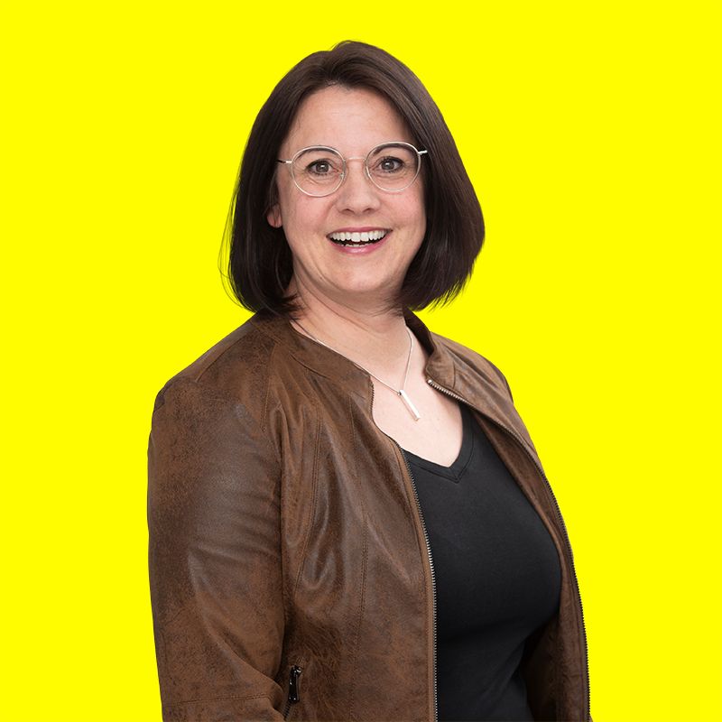 Portrait von Tanja Riehle auf gelbem Hintergrund.